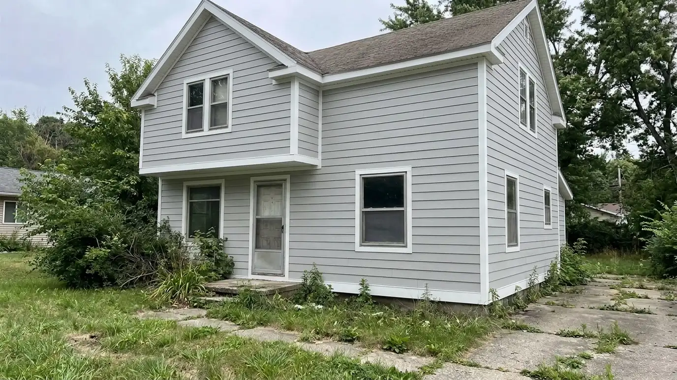 After: a house exterior with crisp light gray fiber cement lap siding with white trim and clean corners